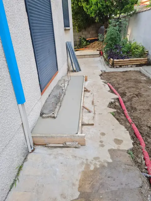 Coffrage d'une allée en béton le long d'une maison