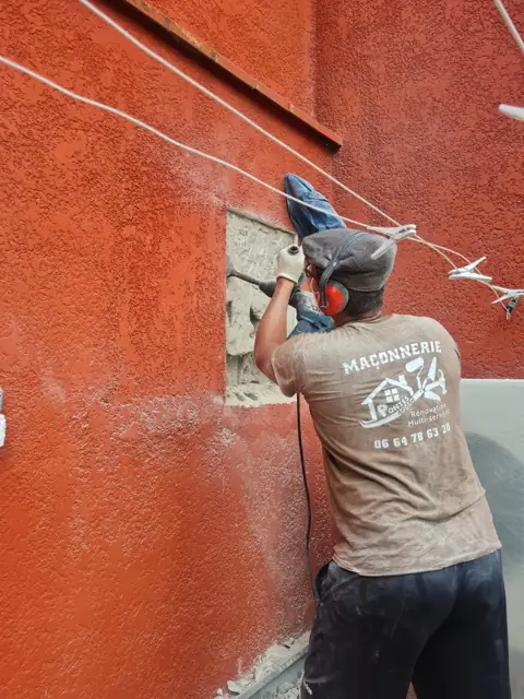 Maçon de Pontes Maçonnerie en train d'ouvrir un mur de façade
