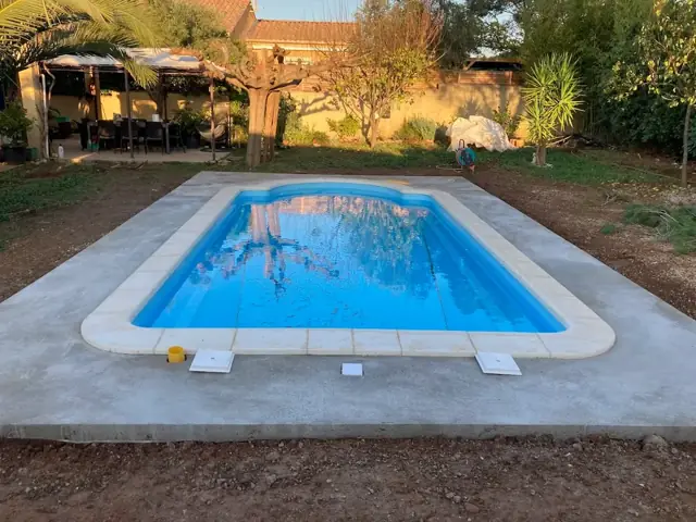 Plage de piscine en béton terminée autour d'un bassin